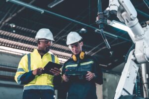 Industriarbetare intill robot