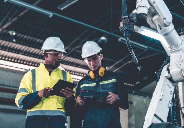 Industriarbetare intill robot